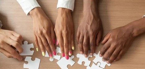 Photo of hands putting together a puzzlee